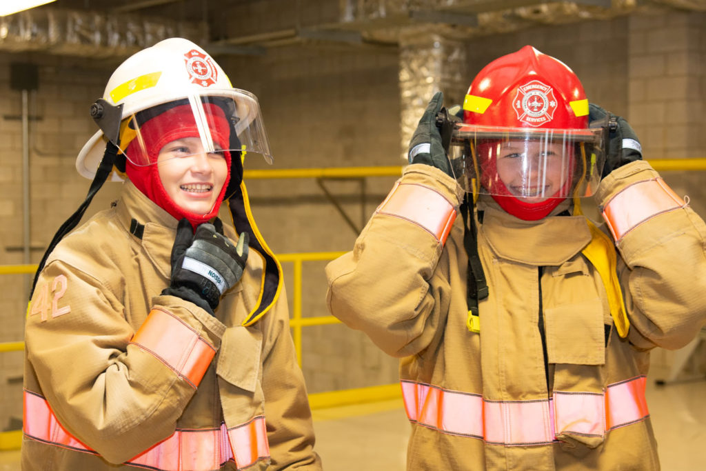 Youth try on firefighter gear at Take Our Kids to Work Day