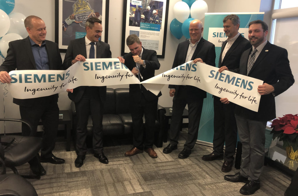 Dignitaries cut ribbon at Siemens office