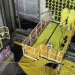 Unit 4 reactor face with two workers in yellow suits