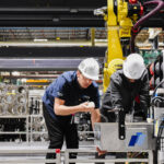 two workers inspecting automated tooling