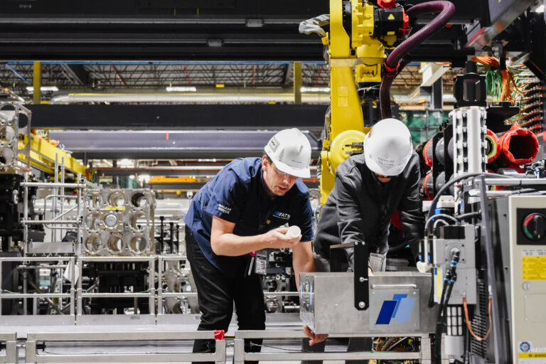 two workers inspecting automated tooling