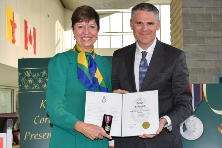 Pam Damoff, Member of Parliament for Oakville North-Burlington and Parliamentary Secretary to the Minister of Foreign Affairs, presents James Scongack with the King Charles III Coronation Medal on behalf of the Government of Canada.