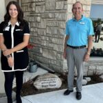 Huron Hospice donation photo with Bruce Power's Calista Powell and Willy Van Klooster in front of building with commemorative stone.