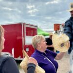 Pat Dalzell, Bruce Power Vice-President, Corporate Affairs and Market Development, hands out company-branded straw hats at the International Plowing Match and Rural Expo in Lindsay.