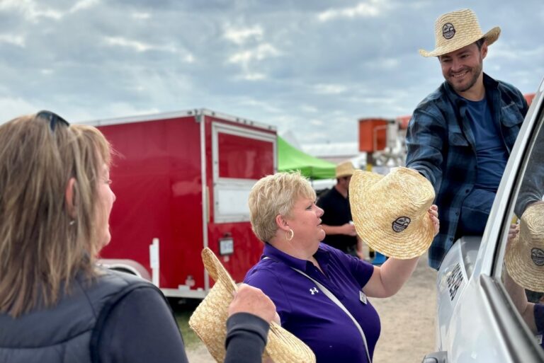 Pat Dalzell, Bruce Power Vice-President, Corporate Affairs and Market Development, hands out company-branded straw hats at the International Plowing Match and Rural Expo in Lindsay.