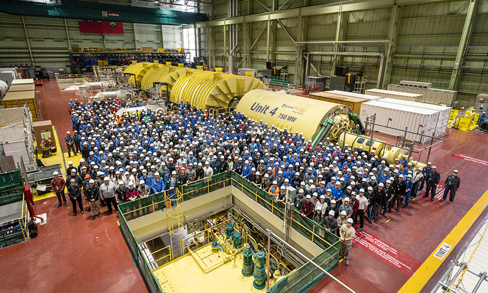 Workers gather on the Unit 4 Turbine Hall floor to commemorate the Unit 4 MCR outage.