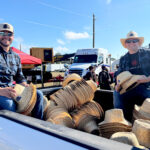 Bruce Power's Pat Dalzell, left, and Clint Thomas hand out hats during the opening parade at the International Plowing Match and Rural Expo.