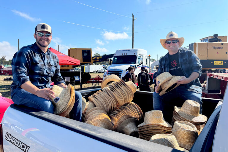 Bruce Power's Pat Dalzell, left, and Clint Thomas hand out hats during the opening parade at the International Plowing Match and Rural Expo.
