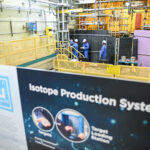 Bruce Power isotope production system. Workers pictured in station near IPS and sign.