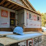 Home construction site showing partially finished home, hard hat. Saugeen First Nation.