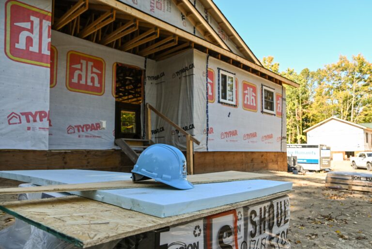 Home construction site showing partially finished home, hard hat. Saugeen First Nation.