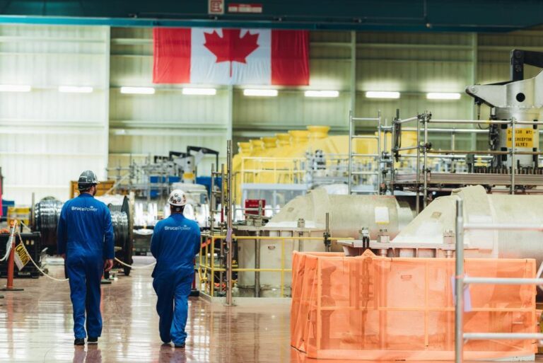 Bruce Power workers shown walking in the turbine hall.