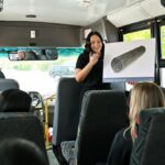A summer student holds up a photo of fuel bundle on a Bruce Power bus tour.