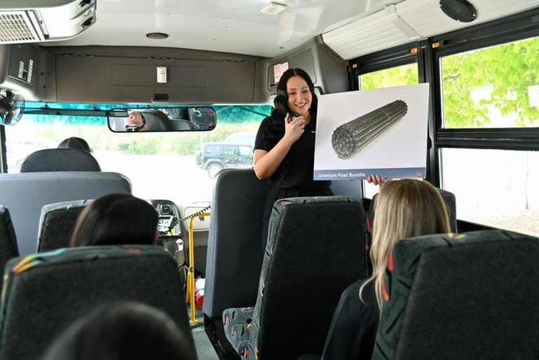 A summer student holds up a photo of fuel bundle on a Bruce Power bus tour.