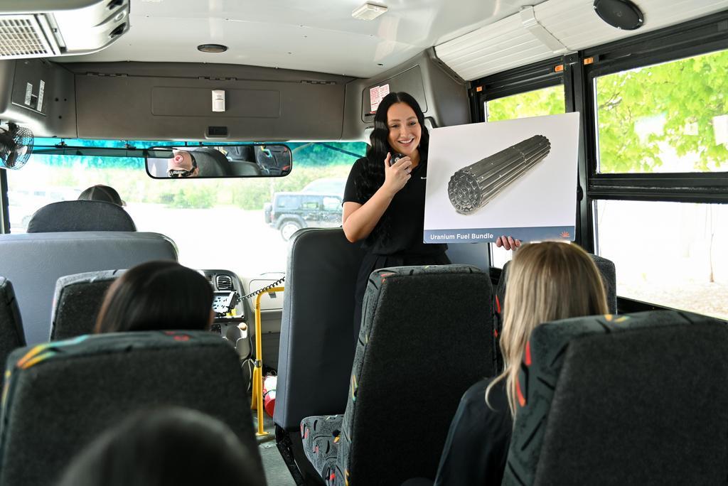 A summer student holds up a photo of fuel bundle on a Bruce Power bus tour.