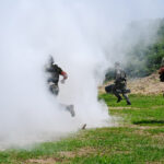 Officers run into smoke during a tactical training exercise and competition.