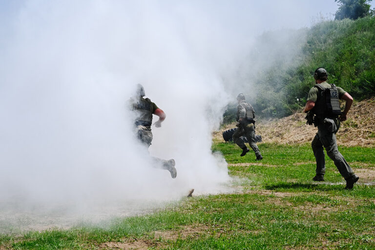 Officers run into smoke during a tactical training exercise and competition.