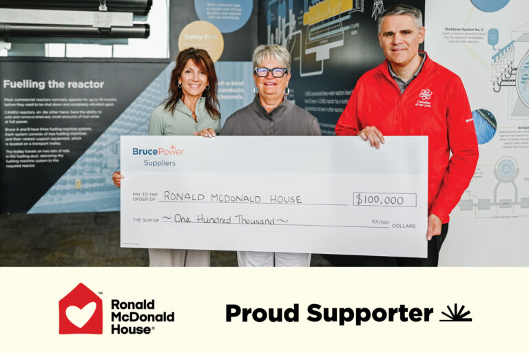 Bruce Power cheque presentation to Ronald McDonald House. Graphics of both organizations saying proud supporter.